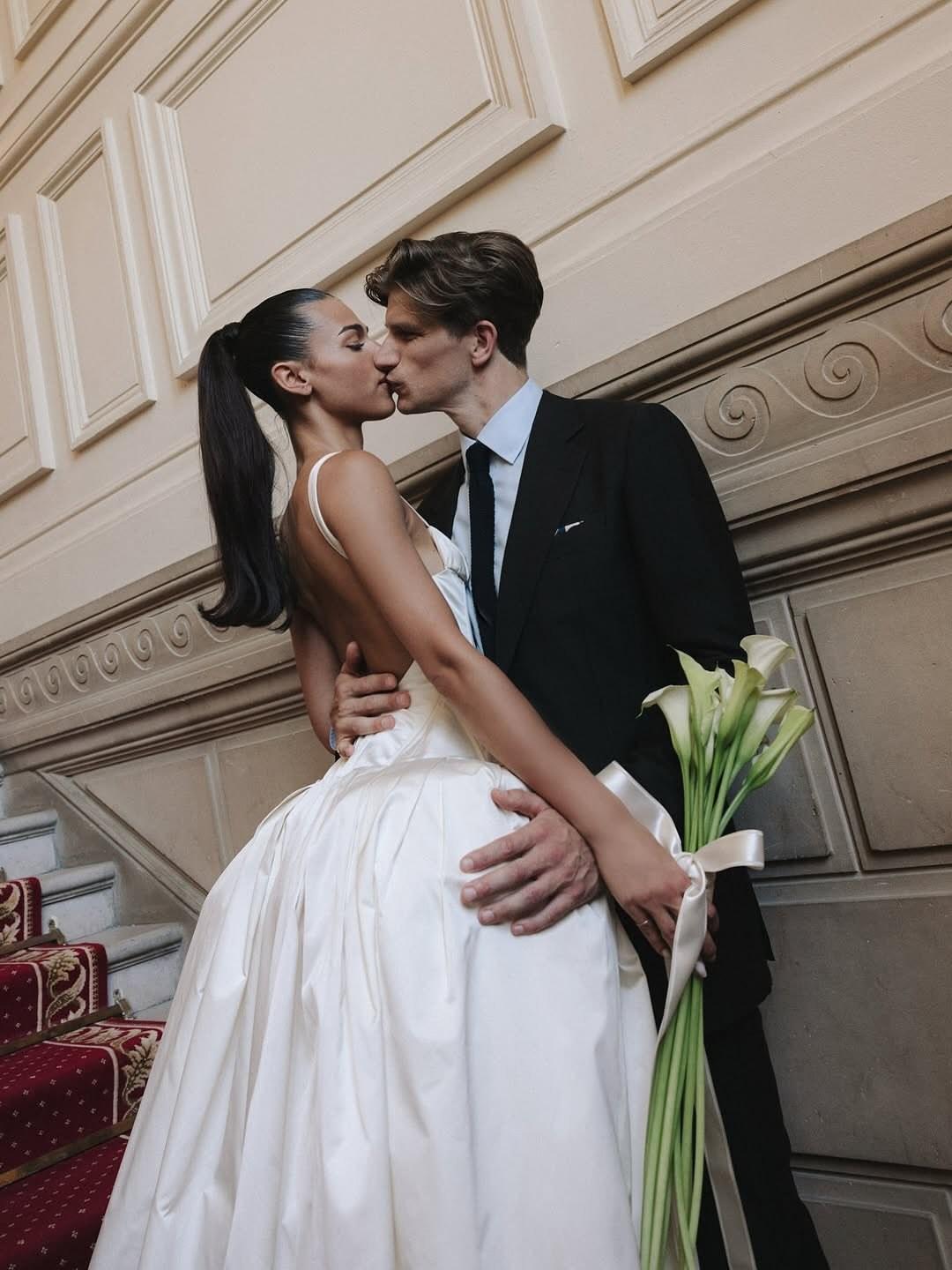 Bride and groom sharing a kiss on a grand staircase