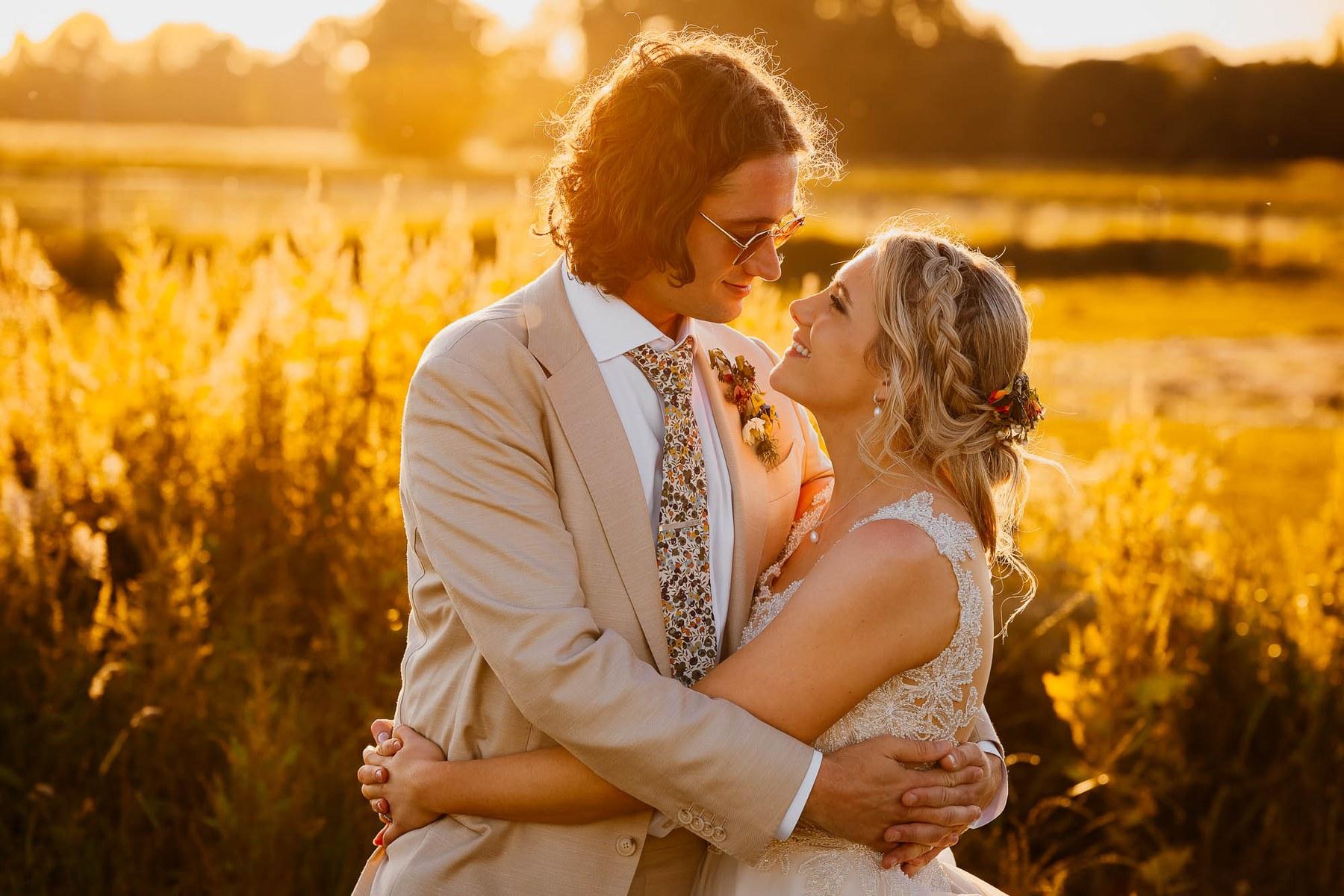 Couple embracing in a golden field at sunset